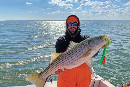 Doug Keeping shows off a nice striped bass caught on a spoon while trolling off the Jersey Shore.
